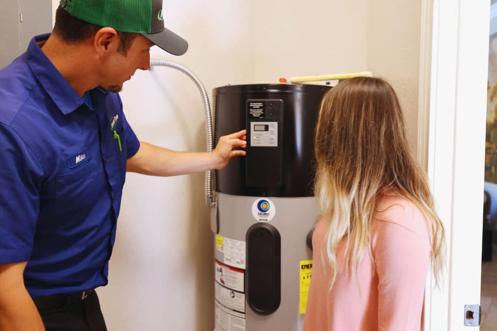 A tech showing a homeowner a water heater.